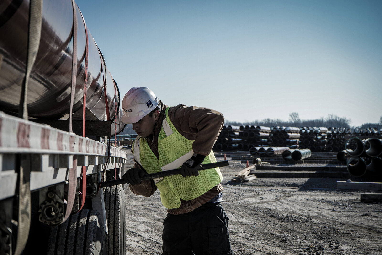 Grid-Line driver strapping steel coils at a pipe yard